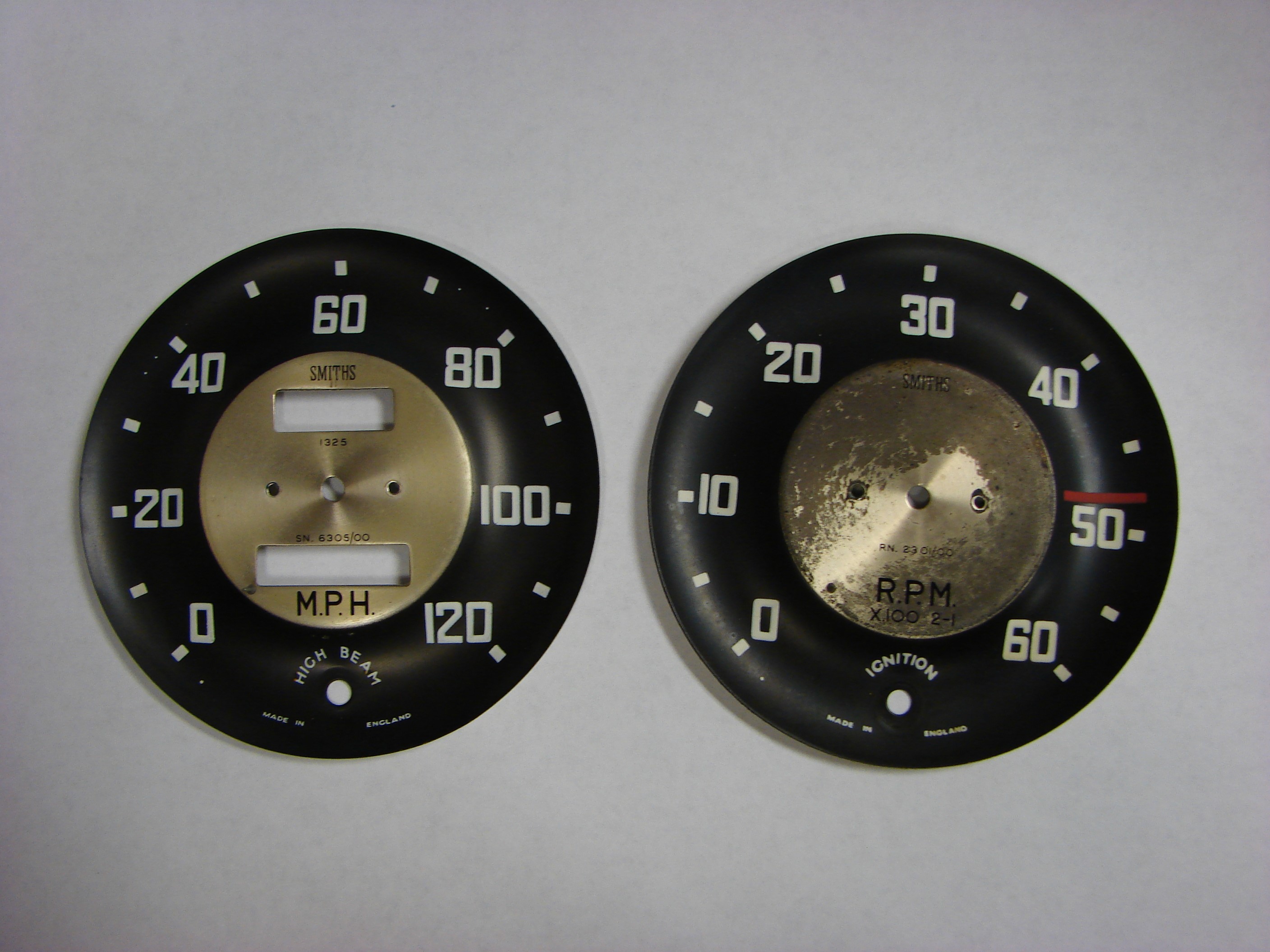 Two black and gold speedometers