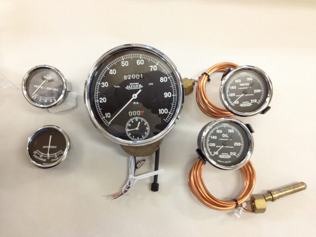 A large speedometer and four smaller devices with wires
