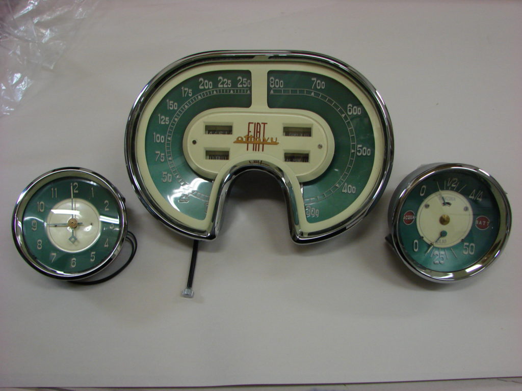 One large uniquely shaped speedometer and two smaller car devices
