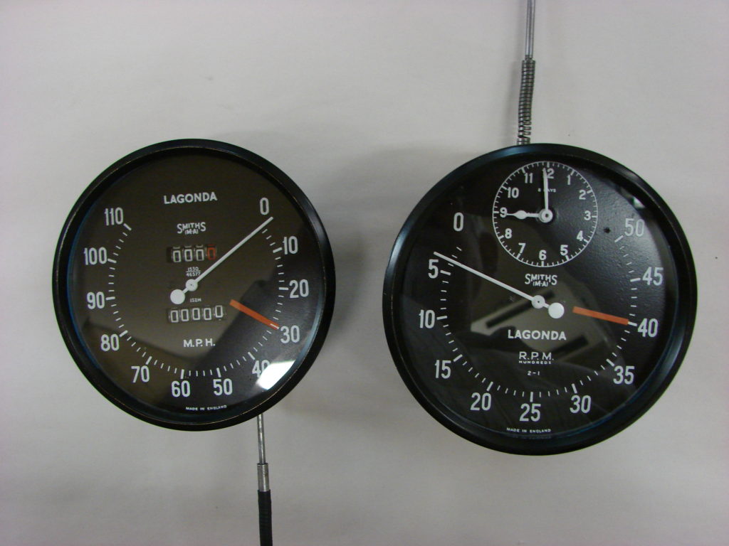 Two black speedometers on a surface